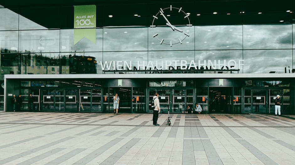 Entrance of Wien Hauptbahnhof with people and modern facade in Vienna, Austria.